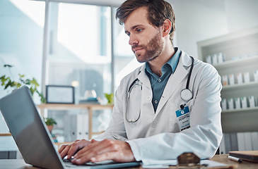 Image showing Man, doctor and laptop typing in healthcare research, communication or social media at office desk. Male medical expert working on computer in online search, browsing or chatting on tablet at clinic