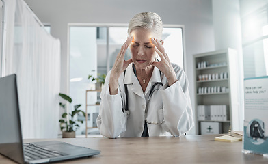 Image showing Headache, stress and female doctor in her office with a laptop in the hospital after a consultation. Frustrated, burnout and senior woman healthcare worker working with a migraine in a medical clinic