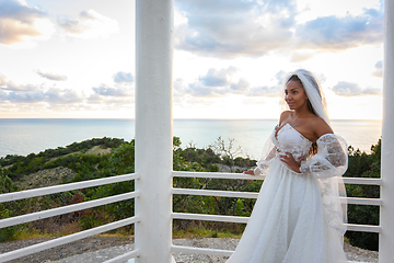 Image showing Bride in a wedding dress in a gazebo with columns on the seashore
