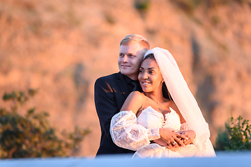 Image showing Happy newlyweds in the rays of the setting sun