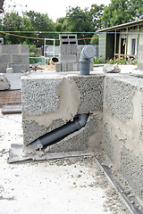 Image showing Laying a sewer pipe in the wall during the construction of a house