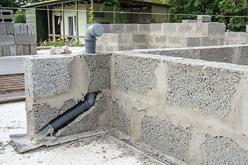 Image showing Laying a sewer pipe in the wall during the construction of a house