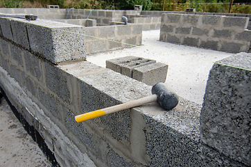 Image showing Mallet lies on part of the wall during the construction of a residential building