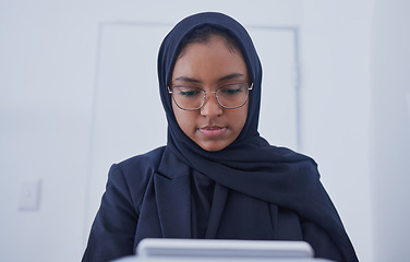 Image showing Muslim, tablet working and hijab of a serious woman employee from Dubai writing code. Islam, web data and coding program of a it worker in a office planning with business software and analytics