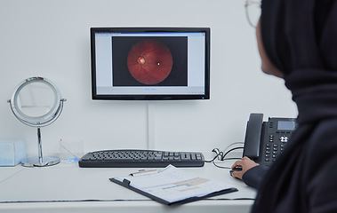 Image showing Eye analysis, optometry and a doctor with a computer for research on a retina and lens problem. Ophthalmology, technology and Muslim woman looking at a monitor screen for eyesight and optic analytics