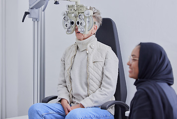 Image showing Optometry, ophthalmology and Islamic optometrist in Dubai consulting a patient for an eye test using a Phoropter for vision. Eyesight, woman and Muslim person with hijab doing optical examination