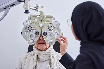 Image showing Eye exam, vision and senior woman with optometrist in clinic for testing eyes, check eyesight and optical care. Optometry, healthcare and Muslim optician with patient, phoropter and medical tools