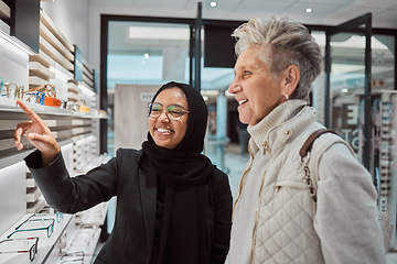 Image showing Decision, glasses and senior woman with an optician for help with eyewear and shopping for a frame. Consulting, talking and Muslim employee helping an elderly patient with choice of eyeglasses