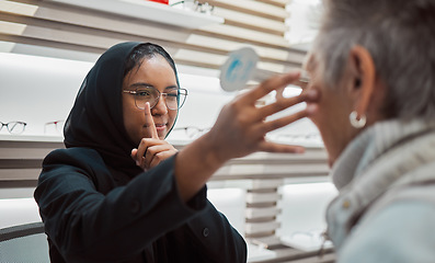 Image showing Optometry, vision and eye test with an islamic woman optician working to diagnose a customer. Doctor, optometrist and eyecare with a muslim female testing a client for prescription lenses in a clinic