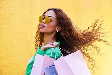 Image showing Classy, retail and portrait of a woman with shopping bags for fashion, luxury sale and discount. Elegant, customer and rich girl in the city to shop, buying clothes and fashionable clothing on a wall