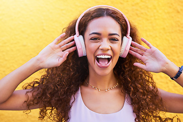Image showing Music, freedom and portrait with a black woman listening to the radio outdoor on a yellow wall background. Headphones, energy and face with an attractive young female streaming audio sound for fun