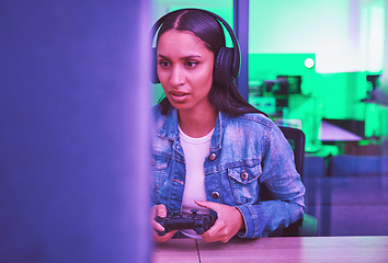 Image showing Gamer, headphones and woman on computer in home at night in green neon light for web esports. Gaming, technology and female with controller playing online games, multiplayer or video game in house.