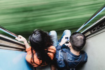 Image showing Couple traveling by train. Motion blured image creating impression of movement and speed.