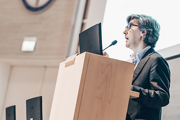 Image showing Speaker giving talk on podium at Business Conference.