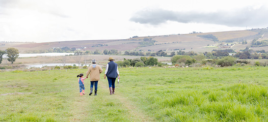 Image showing Agriculture, field in countryside with family walking on farm and back view, green and sustainability with agro. Fresh air, farming and farmer with people outdoor, holding hands and environment