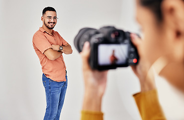 Image showing Shooting, photography and photographer with man model in studio for creative, advertising and image. Media, backstage and professional woman videographer with guy, camera and equipment for photoshoot