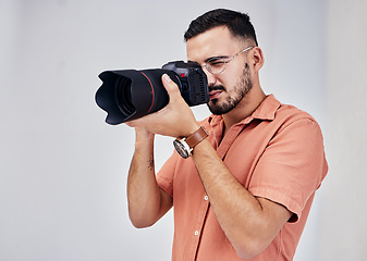 Image showing Photographer, camera and art with a man in studio on a gray background for modern or creative photography. Media, production and photoshoot with a male photo professional or artist working backstage