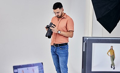 Image showing Serious, photographer and man on camera in studio for shoot, magazine project or online content. Backstage or male thinking for digital profession, fashion web design or creative internet catalog