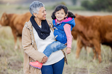Image showing Grandmother, happy girl portrait and nature with cows and senior woman in the countryside. Outdoor field, hug and elderly female with child on a family adventure on vacation with happiness and fun