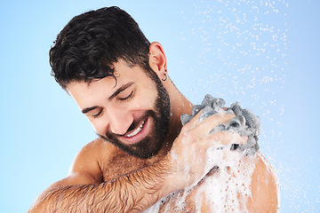 Image showing Shower, loofah and man in studio for grooming, hygiene and wellness with soap against blue background. Body care, skincare and male model relax with luxury, foam and product, exfoliation and cleaning