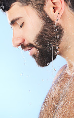 Image showing Water, shower and profile of a man in bathroom for cleaning, skincare and hygiene wellness. Isolated, blue background and studio with a male model with dermatology facial and self care routine