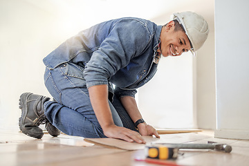 Image showing Handyman, wood flooring installation and happy at workplace, industry and home development vision. Black man, construction worker and floor with smile, helmet and tools for diy, interior and design