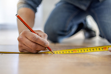 Image showing Handyman, floor and hands to measure with pencil, tape and diy for home improvement, maintenance and building. Builder, construction worker and flooring with writing, planning and vision in workplace