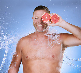 Image showing Grapefruit in hand, water and man with face, beauty and skincare, eco friendly and organic on studio background. Hydration, vitamin c and hygiene, senior male in portrait, smile and citrus fruit