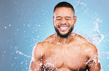 Image showing Shower, beauty and water splash for man cleaning, hygiene and skincare isolated in studio blue background. Happy, aqua and model washing smooth skin with glow smile, closed eyes and mockup