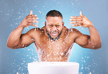 Image showing Water splash, hands or black man cleaning face for beauty, skincare or fresh hygiene on blue background. African male model with wellness washing, grooming or cleansing for facial treatment in studio