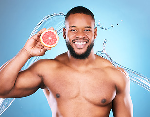 Image showing Portrait, happy or black man with grapefruit for facial skincare cleaning, vitamin c or cosmetic benefits in studio. Smile, dermatology or young male beauty model cleaning a glowing face for wellness