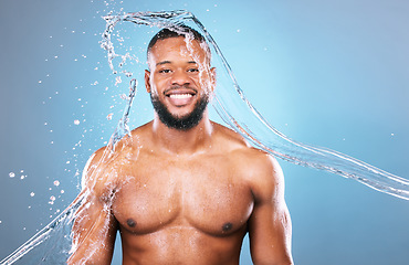 Image showing Muscle, portrait and water on black man cleaning, hygiene and skincare isolated in studio blue background. Bodybuilder, aqua and model washing smooth skin with glow smile and happy for wellness