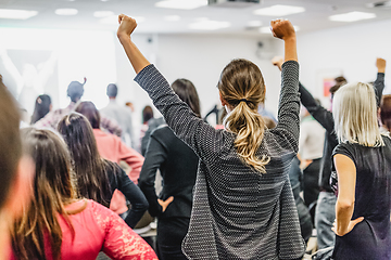 Image showing Participants of interactive motivational speech feeling empowered and motivated, hands raised high in the air.