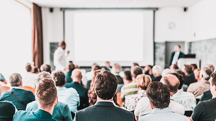 Image showing I have a question. Group of business people sitting in conference hall. Businessman raising his arm. Conference and Presentation. Business and Entrepreneurship