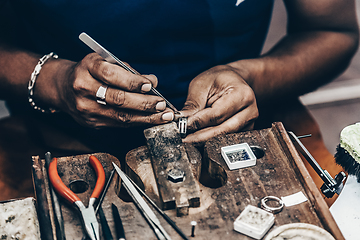 Image showing Jeweler making handmade jewelry on vintage workbench.