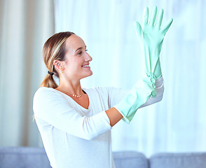 Image showing Woman, gloves and cleaning for hygiene, disinfectant and cleaner ready to start the day, housekeeping and sanitary. Female, lady and maid in living room, dust and dirt with bacteria and rubber safety