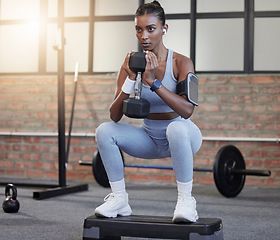 Image showing Woman, fitness and weightlifting dumbbells in squat at gym for intense exercise, workout or strength training. Serious female lifting weights and exercising for healthy wellness or bodybuilding