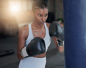 Image showing Fight, black woman and boxing for fitness, focus and motivation for exercise, workout or wellness. Boxer, female athlete and confident lady in gym, fist gloves and determined with endurance or energy