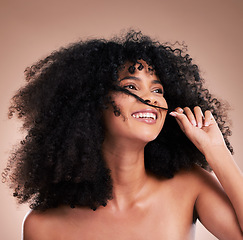 Image showing Afro, beauty and face of black woman with hair in hands on brown background for wellness, shine and natural glow. Salon, luxury treatment and happy girl smile with curly hairstyle, texture and growth