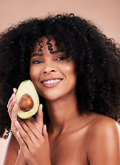 Image showing Face portrait, hair care and black woman with avocado in studio isolated on a brown background. Food, skincare and happy female model with fruit for healthy diet, nutrition or vitamin c and minerals.