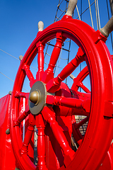 Image showing Red wheel helm on antique ship