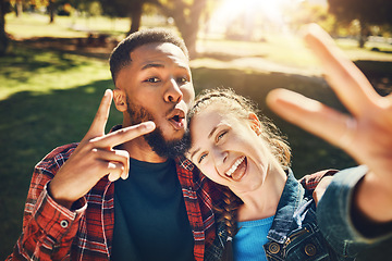 Image showing Couple smile, selfie peace sign and portrait outdoors, laughing at funny joke and bonding in nature. Diversity, love romance and black man and woman with v hand emoji to take photo for happy memory.
