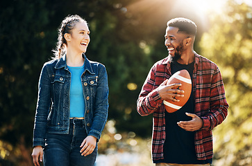 Image showing Couple laughing, American football in park and happy together in nature, walking outdoor and sports in the sun. Commitment, trust and fitness, black man and woman, interracial couple and funny joke