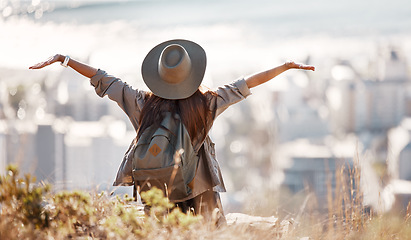 Image showing Woman, tourist and hiking or travel freedom in city for adventure, backpacking or journey on mountain in nature. Female hiker with open arms enjoying fresh air, trekking or scenery of an urban town