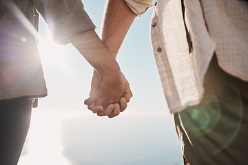Image showing Love, unity and couple holding hands on the beach while on a date for romance or their anniversary. Trust, support and closeup of man and woman with hand intimacy and affection while on outdoor walk.