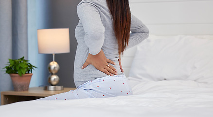 Image showing Tired, feeling and pregnant woman with back pain on a bed for rest, injury and fatigue. Healthcare, stress and girl with backache during pregnancy in her bedroom with morning sickness and cramps