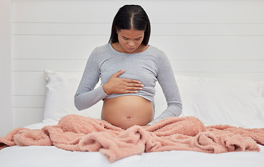 Image showing Pregnant, hands on stomach and mother in bed holding abdomen for baby, infant and child affection at home. Pregnancy love, family and excited, loving and happy woman rest, relax and calm in bedroom