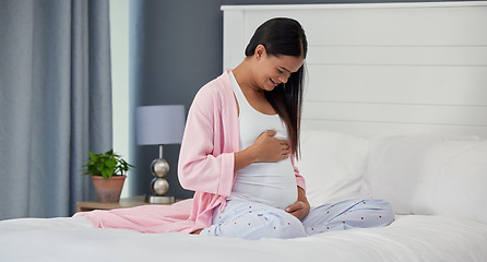 Image showing Pregnant woman, stomach and love in home bedroom happy about bonding and movement. Mother to be person with hands on abdomen for healthy pregnancy development, body wellness and care on her bed