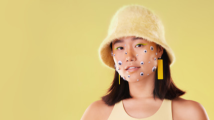 Image showing Fashion, portrait and Asian woman with funny eyes isolated on a yellow background in a studio. Face of aesthetic girl with mockup space for advertising and art for gen z cosmetics and creative beauty