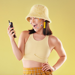 Image showing Asian woman, cellphone and studio for surprise, fashion or eyes sticker art on face with smile for social media. Happy gen z model, 90s aesthetic and phone for communication, chat and app with wow